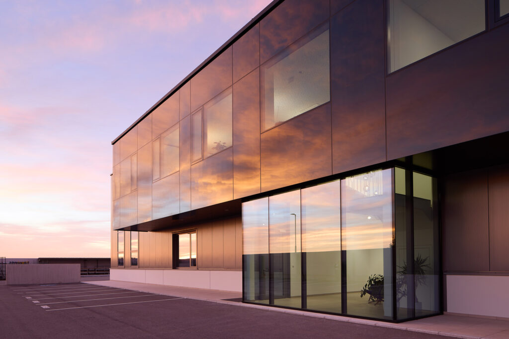 Firmengebäude von Metallbau Blauensteiner - moderne Architektur im effektvollen Licht eines Sonnenuntergangs